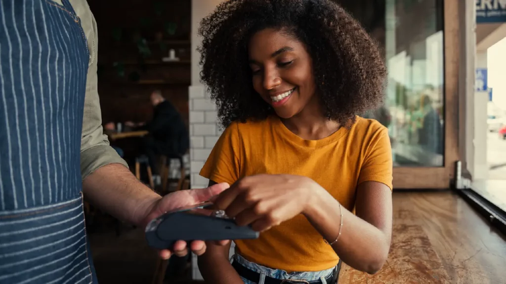 contactless payments_.woman using contactless payment to pay at a cafe_Shift4